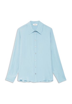 Svijetloplava košulja s dugim rukavima od glatke tkanine. Ima ovratnik sa šiljastim vrhom i kopčanje sprijeda sa srebrnim gumbima.