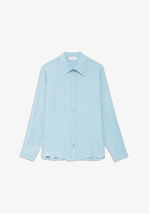 Svijetloplava košulja s dugim rukavima od glatke tkanine. Ima ovratnik sa šiljastim vrhom i kopčanje sprijeda sa srebrnim gumbima.