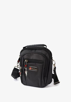 Schwarze Stoff-Schultertasche mit strukturierter Oberfläche, Reißverschlussfächern und abnehmbarem Schultergurt. Verfügt über ein silbernes Logo und einen dekorativen Schlüsselanhänger.