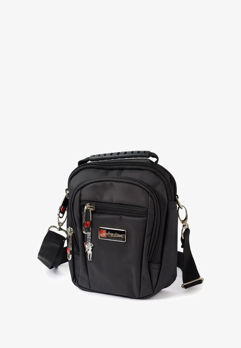 Schwarze Stoff-Schultertasche mit strukturierter Oberfläche, Reißverschlussfächern und abnehmbarem Schultergurt. Verfügt über ein silbernes Logo und einen dekorativen Schlüsselanhänger.