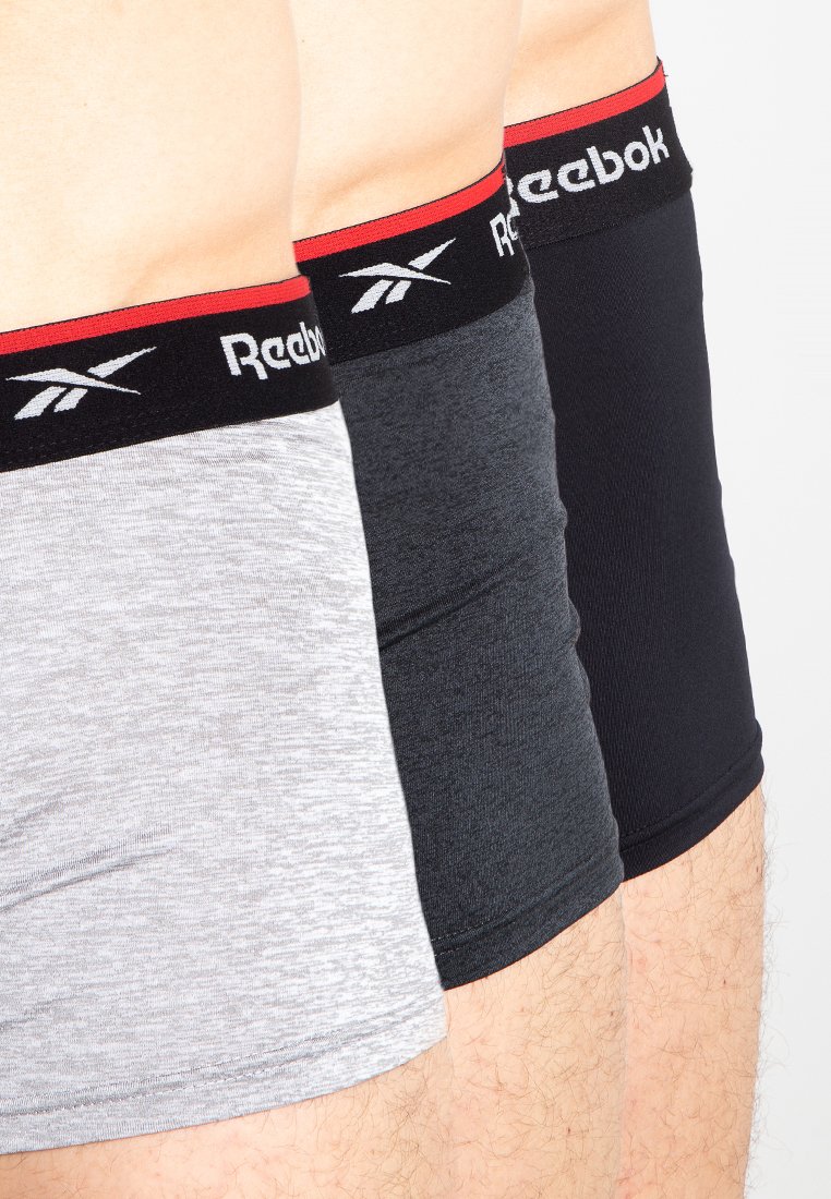 Tres pares de bóxer Reebok en gris, carbón y negro. Cada uno presenta una cinturilla elástica negra con un acento rojo y el logo.