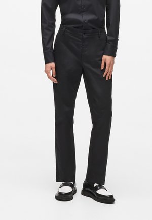 Čierne nohavice vyrobené z hladkej tkaniny, s rovnými nohavicami, prednými vreckami a klasickým zapínaním na gombík a zips.