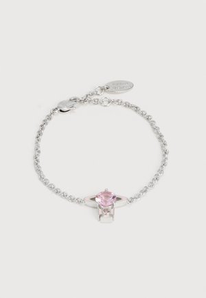 Ασημένιο βραχιόλι με αλυσίδα, με κεντρικό διακοσμητικό ένα ροζ στρογγυλό πολύτιμο λίθο και μια μικρή οβάλ ταμπελίτσα κοντά στην αγκράφα, σε απλό λευκό φόντο.