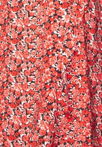 Tissu floral rouge et noir avec de petites fleurs, présentant des nuances variées de rouge et des feuilles blanches, texture lisse et finition douce.