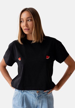Czarna, krótka koszulka z bawełny, z dwoma aplikacjami w kształcie plasterków arbuza na piersi. Krótkie rękawy i luźny krój.