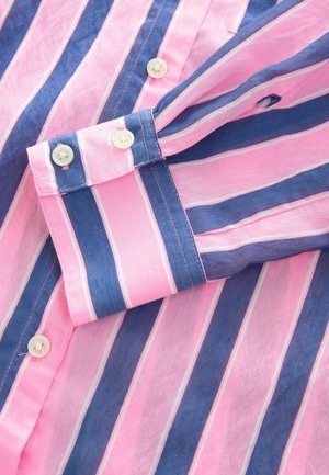Camicia con colletto caratterizzata da strisce verticali rosa e blu navale, con una leggera lucentezza e bottoni bianchi. Il tessuto sembra leggero e testurizzato.