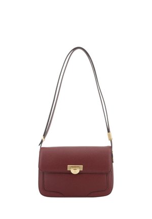 Petit sac à bandoulière en cuir rouge foncé avec un fermoir rectangulaire doré et une fine bandoulière réglable.