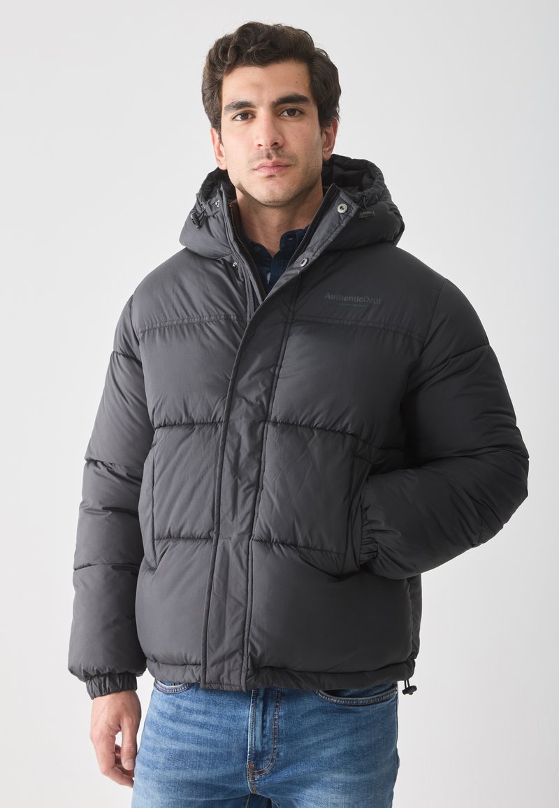 Chaqueta de plumas negra con capucha, que presenta un diseño acolchado y puños elásticos. Adecuada para el clima frío con un ajuste informal.