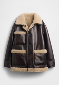 Giacca di pelle marrone con colletto e rivestimento in shearling beige soffice, dotata di due tasche anteriori e chiusure con bottoni.