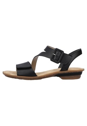Black leather sandal with an ankle strap and buckle closure. Features a flat sole with a light brown footbed and a minimalistic design.