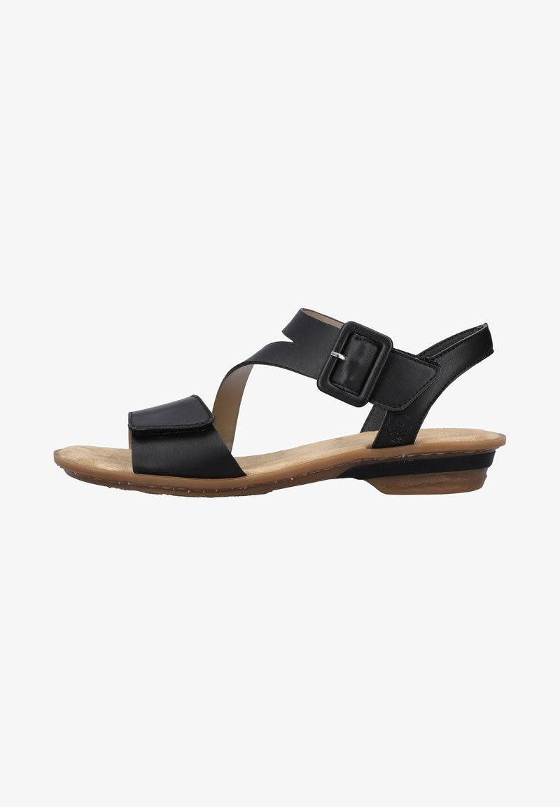 Black leather sandal with an ankle strap and buckle closure. Features a flat sole with a light brown footbed and a minimalistic design.