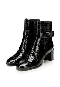Botines negros de tobillo hechos de material brillante con patrón de cocodrilo, con un tacón bloque, cremallera lateral y detalle de correa ajustable.
