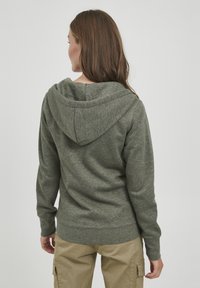 Sweat à capuche vert, à manches longues, en tissu texturé. Présente un design simple, avec des poignets et un ourlet côtelés.