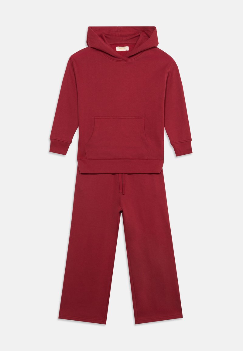 Sweat à capuche marron avec poche avant assorti à un pantalon large assorti sur fond blanc.
