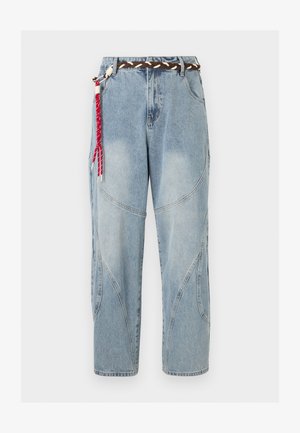 Φωτεινό μπλε τζιν με καμπυλωτές ραφές στα πάνελ και πλεκτή καφέ ζώνη με κόκκινη και λευκή υφαντή φούντα στην αριστερή πλευρά.