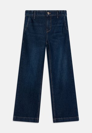 Temno jeans hlače širokega kroja z pasom, sprednjimi žepi in kontrastnim šivanjem. Imajo kovinsko zaponko in zadrgo.