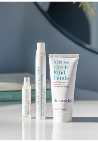 Set van drie huidverzorgingsproducten: een heldere rollerball, een witte sprayfles en een witte tube met blauwe tekst. Alle hebben een strakke, moderne uitstraling.