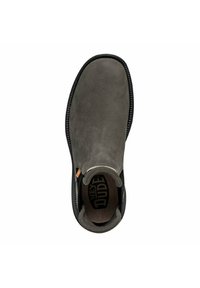 Zapato gris sin cordones de ante con una textura suave, punta redonda y suela negra contrastante; presenta un branding minimalista en el interior.