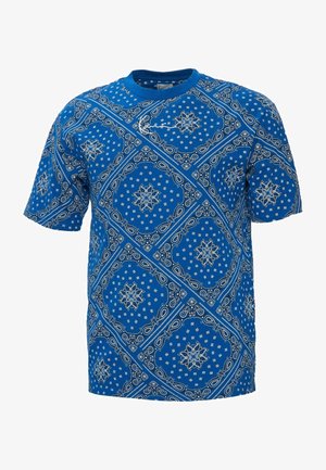 Blue cotton t-shirt featuring a white paisley pattern. Short sleeves, round neckline, and a relaxed fit. Notable intricate designs and textures.