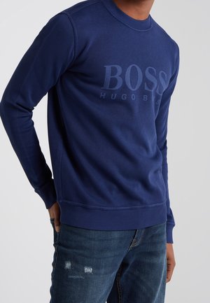 Felpa blu navy in misto cotone, con scollatura rotonda, maniche lunghe, polsini a coste e un grande logo in rilievo sulla parte anteriore.