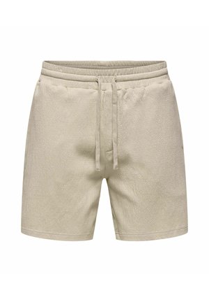 Shorts en tissu éponge beige avec ceinture élastique et cordon de serrage, poches avant, et longueur mi-cuisse.