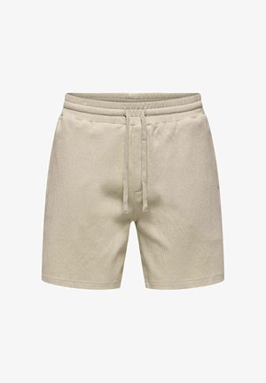 Shorts en tissu éponge beige avec ceinture élastique et cordon de serrage, poches avant, et longueur mi-cuisse.