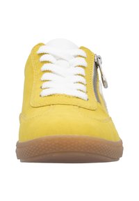 Yellow suede sneaker with white laces, side zipper, and a textured brown rubber sole. Features stitching details and a padded tongue.