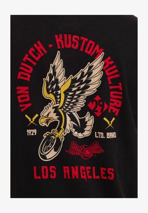 Aigle aux ailes déployées tenant une roue de moto, entouré du texte rouge "Von Dutch Kustom Kulture" et "Los Angeles" sur fond noir.