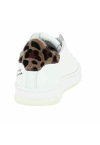Baskets blanches avec un accent en fourrure à motif léopard texturé au talon. Tige en cuir lisse avec une semelle en caoutchouc blanche et des détails de couture.