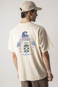 Tricou din bumbac de culoare crem, cu un design grafic colorat pe spate, cu forme geometrice și accente florale, croială lejeră.