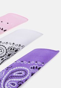 Tre mønstrede bandanas: rosa, hvit og lilla, med svarte paisleymønstre og kantede kanter, laget av lett stoff.