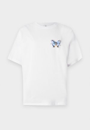 T-shirt en coton blanc avec un imprimé coloré de papillon sur la poitrine gauche. Manches courtes et coupe décontractée.