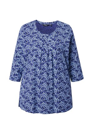 Blå blomster tunika med trekvartlange ærmer. Har rund halsudskæring og læg foran. Blødt, let stof med varieret blomsterprint.