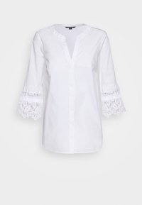 Blusa blanca de algodón con escote en V, mangas de tres cuartos y detalles de encaje en los puños. Textura suave, diseño clásico.