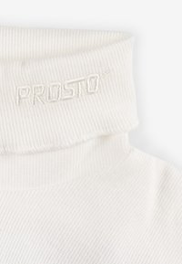 Biała prążkowana golf z wywiniętym kołnierzem. Ozdobiony haftowanym logo "PROSTO" w dopasowanym białym niciu. Miękka, teksturowana tkanina.