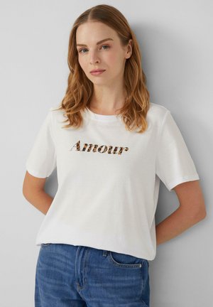 T-shirt en coton blanc à manches courtes, arborant un graphique « Amour » au design léopard sur la poitrine. Coupe décontractée.