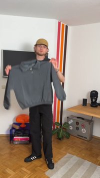 Sweatshirt cinza de pulôver com gola alta e fecho de correr, apresenta punhos e bainha canelados. O material parece macio com um ajuste casual.
