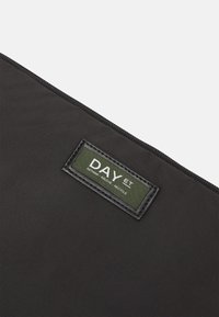 Black fabric pouch featuring a textured surface and a green label with white text. The label reads "DAY ET" and includes the phrase "RETHINK, RELOVE, RECYCLE."