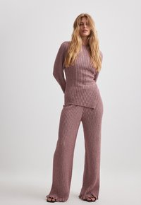 Completo a due pezzi in tessuto a costine, colore mauve chiaro. Maglione a maniche lunghe con taglio dritto e pantaloni con un leggero svaso all'orlo.