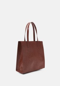 Borsa tote in pelle marrone con motivo coccodrillo, dotata di due manici robusti, una forma rigida e una superficie liscia e strutturata.