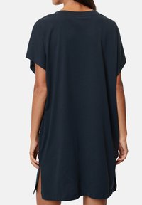 Abito t-shirt oversize blu navy, maniche corte, orlo curvo con spacchi laterali, materiale morbido, vestibilità casual, design minimalista.