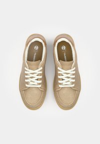 Beige sneakers med overdel i filt, hvite snørebånd og gummisåle. Har en myk fôr og en logo på tungen. Rund tådesign.