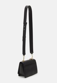 Schwarze Lederhandtasche mit strukturiertem Obermaterial, goldenen Beschlägen und einem verstellbaren Tragegurt. Verfügt über eine strukturierte Form und einen flachen Boden.