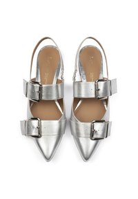 Scarpe slingback argento a punta con cinturini larghi fissati da grandi fibbie in metallo; texture metallica liscia e dettagli sottili sulla soletta.