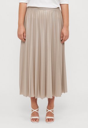 Light beige pleated midi skirt with a smooth, shiny texture and elastic waistband, paired with white strappy sandals.