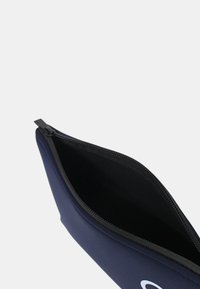 Astuccio a matita in neoprene blu navy con chiusura a zip, caratterizzato da una superficie esterna liscia e un interno nero. Logo visibile su un lato.