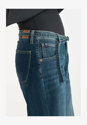 Donkerblauwe spijkerbroek met een rechte snit, voorzien van een bruine leren label, contrasterende stiksels en een ontwerp met zijzakken.