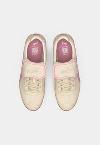 Beige sneakers med rosa aksent. Glatt lærtekstur, rund form, snøring og borrelåsrem. Innvendig har de rosa fôr og QR-kode.