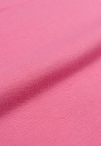Tessuto di cotone rosa pallido con una consistenza liscia, che mostra un motivo di maglia fine. La superficie è leggermente riflettente e uniforme nel colore.