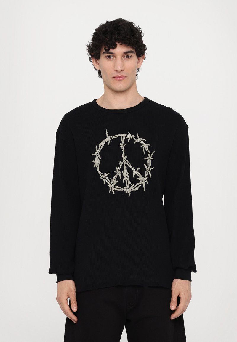 Black long-sleeve shirt with ribbed texture featuring a peace symbol embroidered in light-colored barbed wire design.